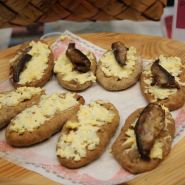 (FOTO: Finntastic) Karelische Piroggen stammen ursprünglich aus Ostfinnland.  Die Teigtaschen aus Roggenmehl  sind aber mittlerweile in ganz Finnland verbreitet. Es gibt sie mit Reis-, Kartoffel- oder fleischhaltiger Füllung. Besonders lecker sind sie mit Eibutter (munavoi) und Muikut (Maränen).  Die Piroggen auf dem Foto hat Anni Inkeri Korhonen gebacken. Bei einem karelischen Dinner können die Gäste in ihrem Gasthaus Puukarin Pysäkki in Valtimo in die Kulinarik Ostfinnlands eintauchen. www.puukarinpysakki.com