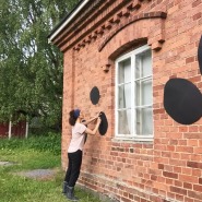 (PHOTO: Valentina Carini) Valentina is decorationg the brick walls of her art studio at the art centre in the Finnish countryside.