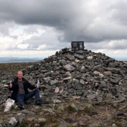 (FOTO: Mikael Diehl) Auf dem Gipfel des Pallastunturi: Mika vor dem Denkmal von Paavo Nurmi. Im Hintergrund ziehen bereits dunkle Wolken auf.