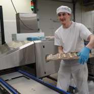 (FOTO: Inken Paletta, Finntastic) Ein Mitarbeiter mit einem Blech voller Piroggen.